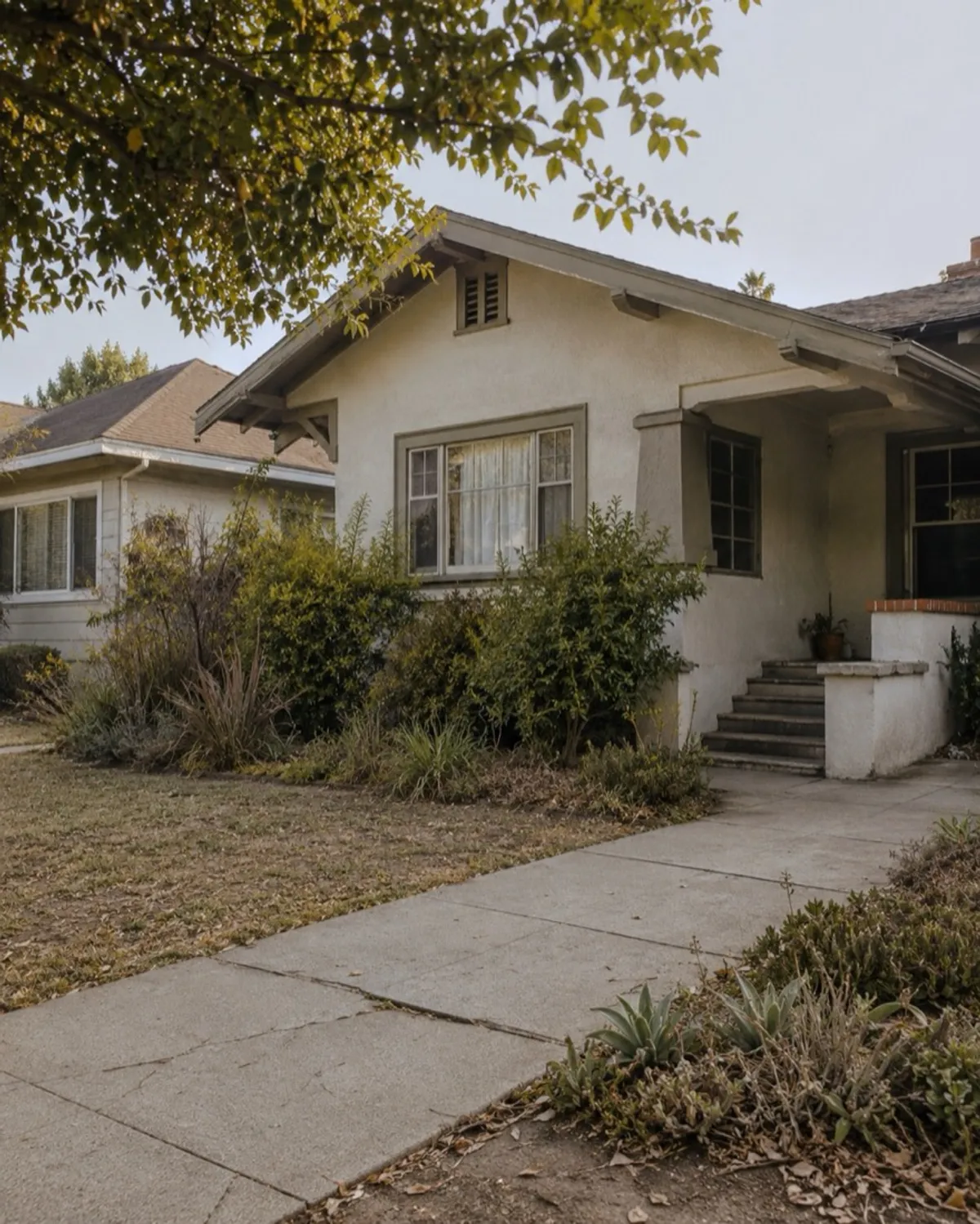 Craftsman bungalow with a front garden and concrete walkway in Los Angeles
